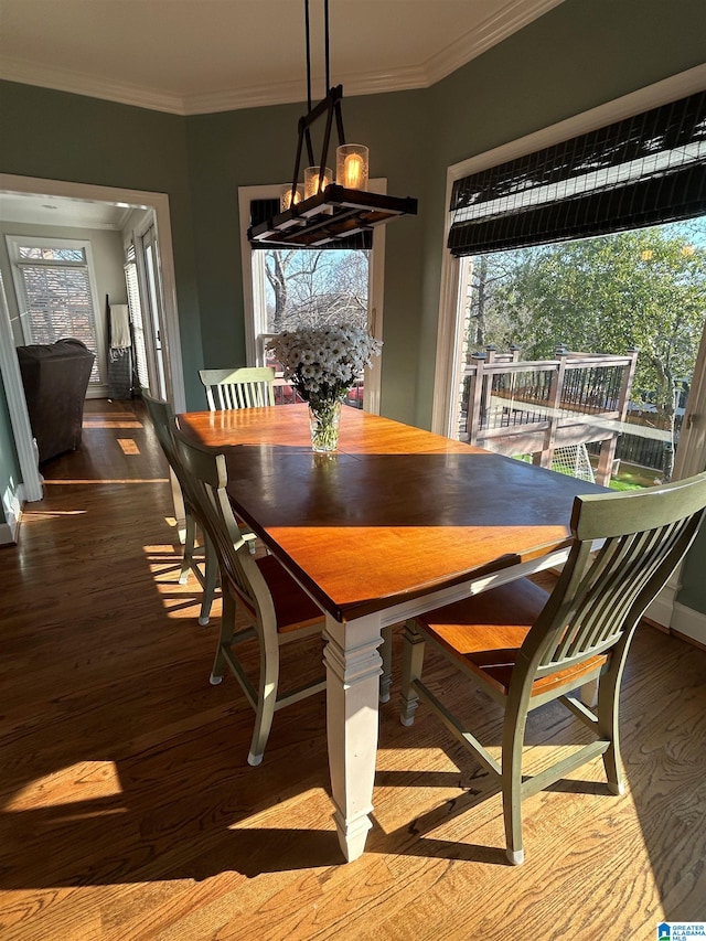 dining room with ornamental molding, baseboards, an inviting chandelier, and wood finished floors