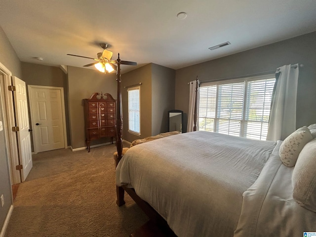 carpeted bedroom with baseboards, visible vents, and a ceiling fan