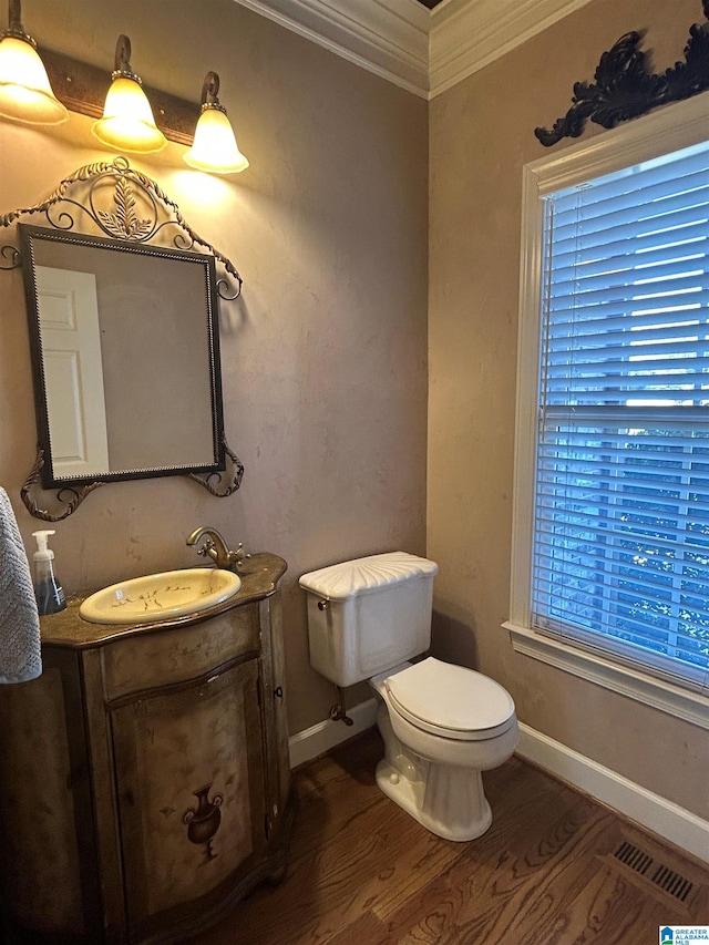 bathroom with baseboards, visible vents, toilet, wood finished floors, and vanity