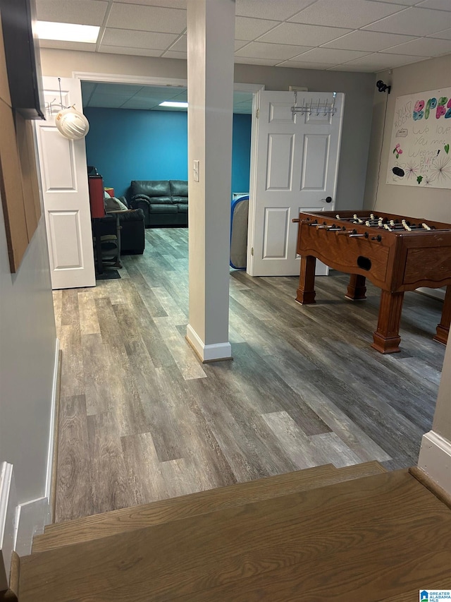 playroom with a paneled ceiling and wood finished floors