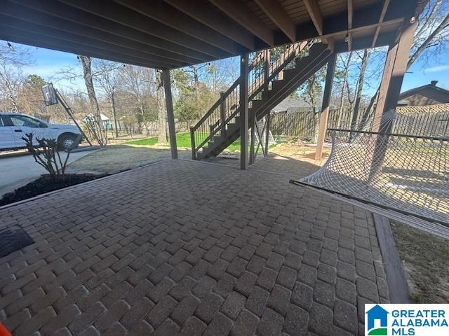 view of patio / terrace featuring stairway and fence