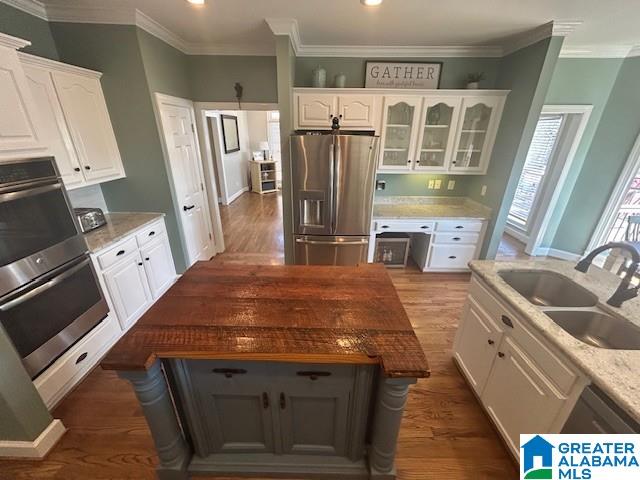 kitchen with white cabinets, dark wood-style flooring, stainless steel appliances, and a sink