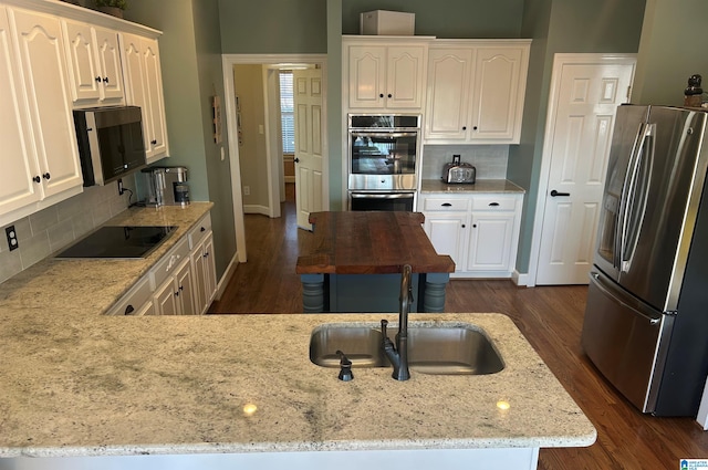 kitchen featuring appliances with stainless steel finishes, dark wood-type flooring, and white cabinetry