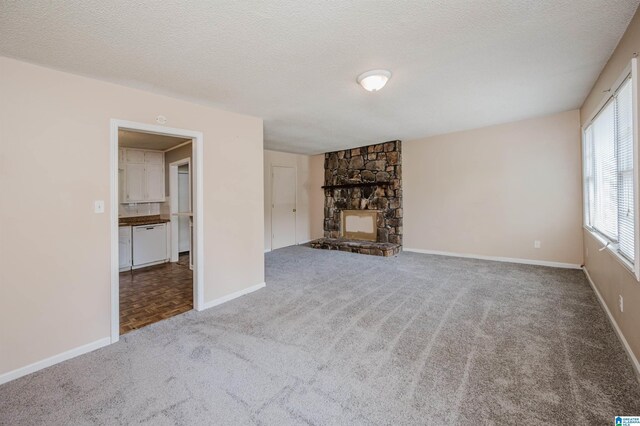 unfurnished living room featuring carpet, a textured ceiling, a fireplace, and baseboards