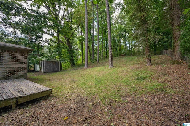 view of yard with an outbuilding, a wooden deck, and a storage unit