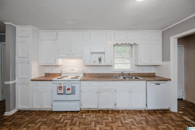 kitchen featuring white appliances, dark countertops, under cabinet range hood, white cabinetry, and a sink