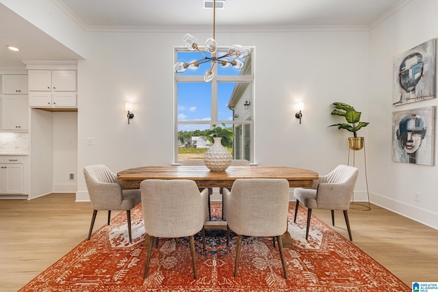 dining space with light wood finished floors, baseboards, ornamental molding, and an inviting chandelier