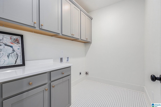 washroom with washer hookup, cabinet space, and baseboards