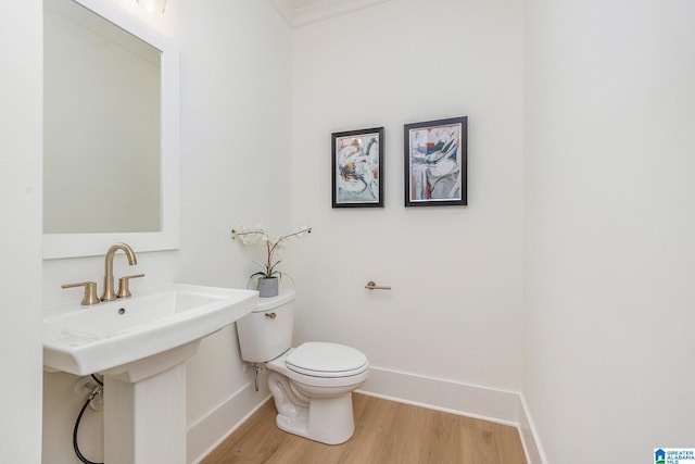 bathroom featuring baseboards, toilet, and wood finished floors