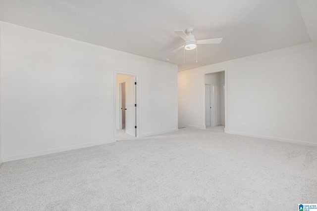 empty room featuring a ceiling fan, light carpet, and baseboards