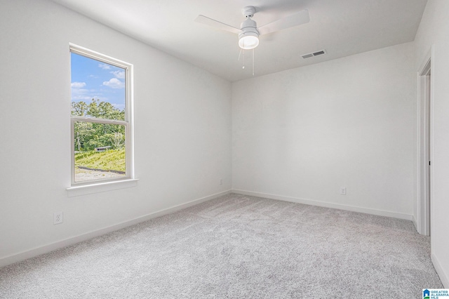 spare room with baseboards, carpet, visible vents, and a ceiling fan