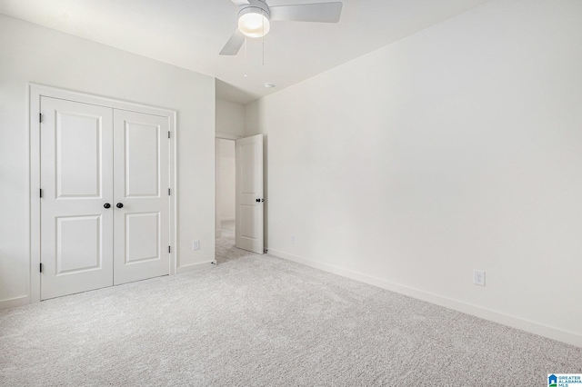 unfurnished bedroom with ceiling fan, baseboards, a closet, and light colored carpet