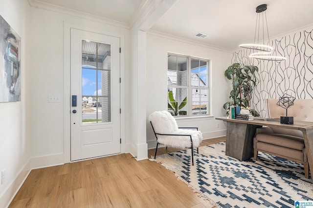 entrance foyer featuring light wood-style floors, visible vents, and crown molding