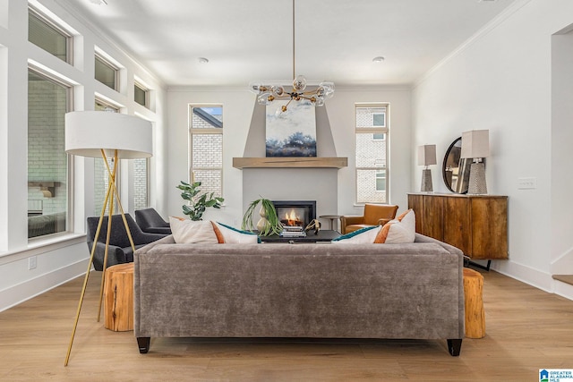 living area with light wood-type flooring, plenty of natural light, and crown molding