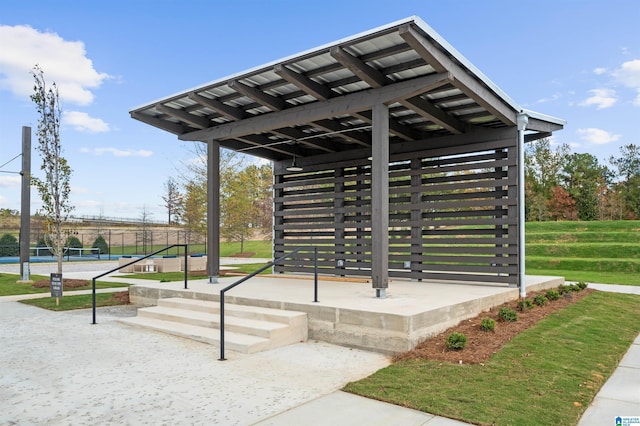 view of community featuring a tennis court and fence