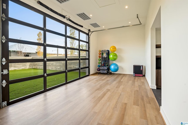 exercise room with baseboards, recessed lighting, visible vents, and light wood-style floors