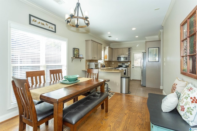 dining room featuring light wood-type flooring, a notable chandelier, crown molding, and recessed lighting