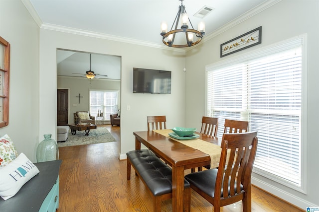 dining space with ornamental molding, dark wood-type flooring, visible vents, and baseboards