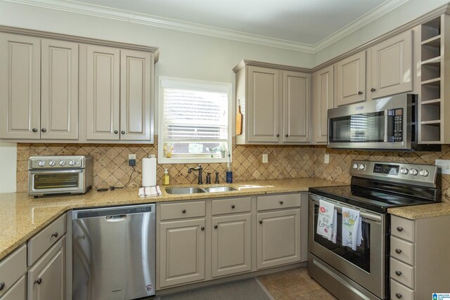 kitchen with decorative backsplash, appliances with stainless steel finishes, tile patterned flooring, crown molding, and a sink