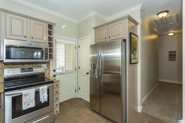 kitchen with appliances with stainless steel finishes, visible vents, crown molding, and cream cabinets