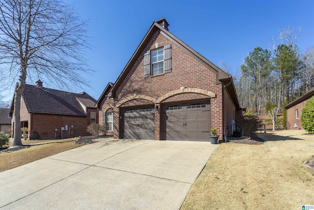 view of front of house featuring a garage, concrete driveway, brick siding, and a front lawn