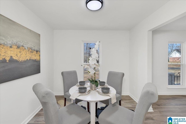 dining area with baseboards and wood finished floors