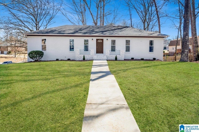 ranch-style home featuring brick siding and a front lawn