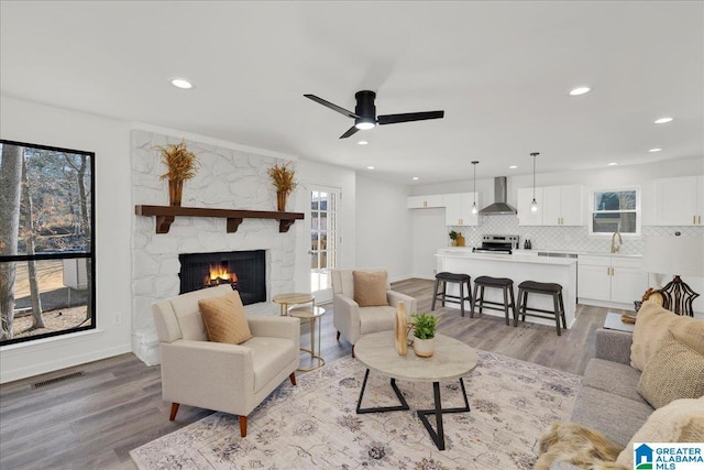 living room featuring light wood finished floors, plenty of natural light, and visible vents