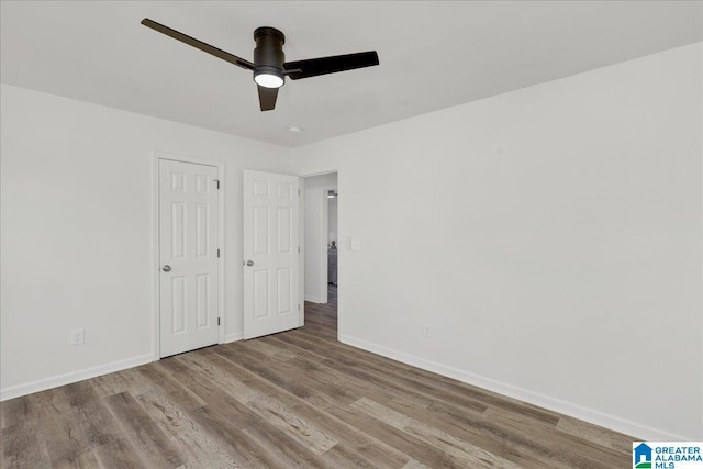 unfurnished bedroom featuring ceiling fan, light wood finished floors, and baseboards