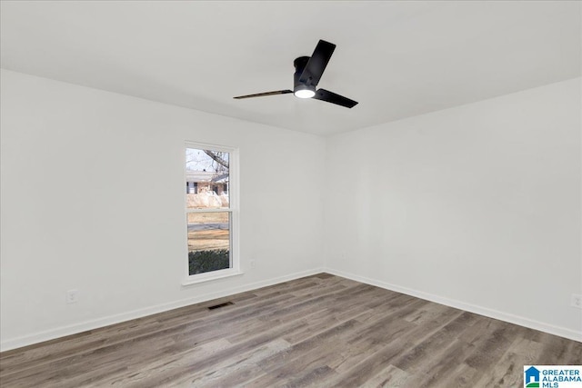 empty room featuring light wood-type flooring, visible vents, ceiling fan, and baseboards