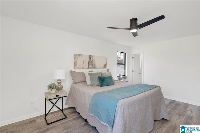 bedroom with ceiling fan, baseboards, and wood finished floors