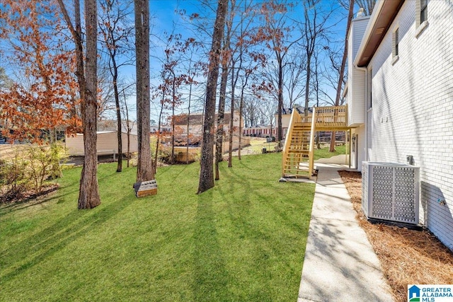 view of yard featuring stairway, a deck, and central AC