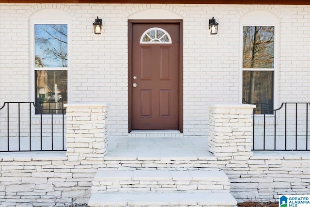 entrance to property featuring brick siding