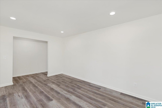 empty room featuring light wood-type flooring, baseboards, and recessed lighting