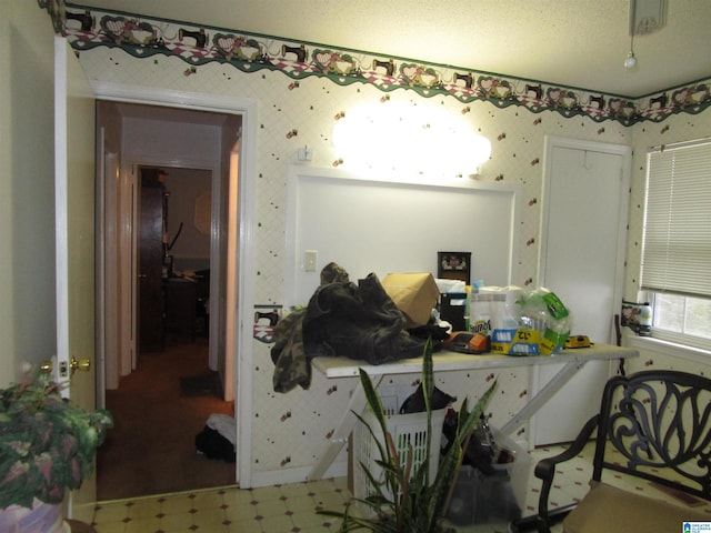 interior space with tile patterned floors, a textured ceiling, and wallpapered walls