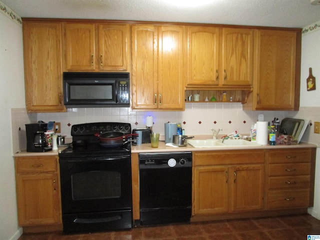 kitchen featuring a sink, black appliances, backsplash, and light countertops