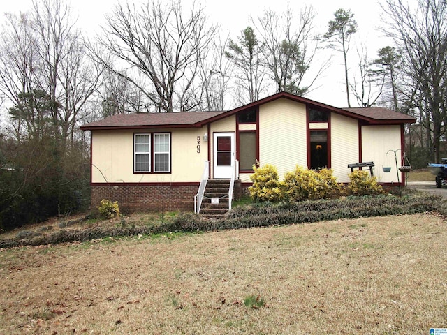 view of front of property featuring brick siding and a front yard