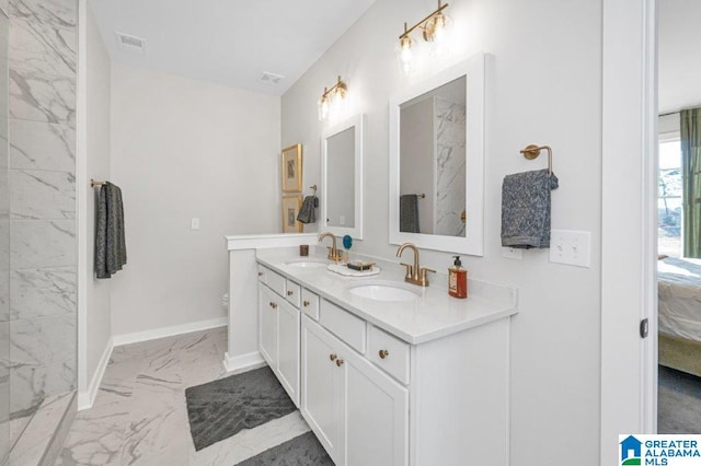 ensuite bathroom with marble finish floor, connected bathroom, visible vents, and a sink