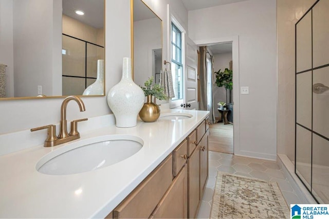 full bathroom with double vanity, a walk in shower, a sink, and tile patterned floors