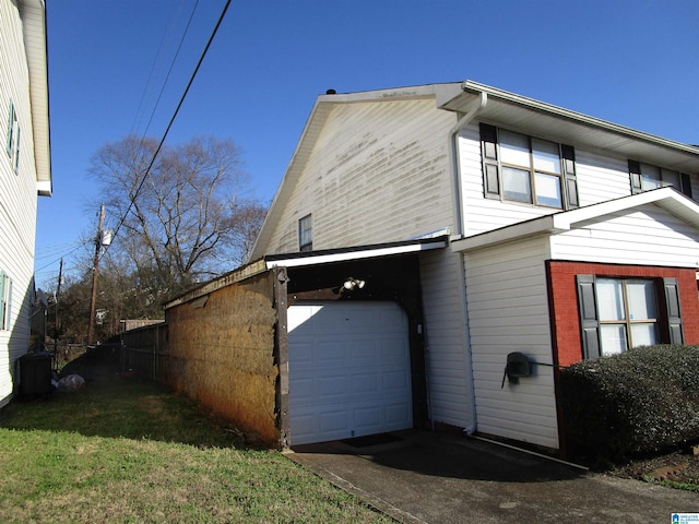 view of side of property featuring driveway and an attached garage