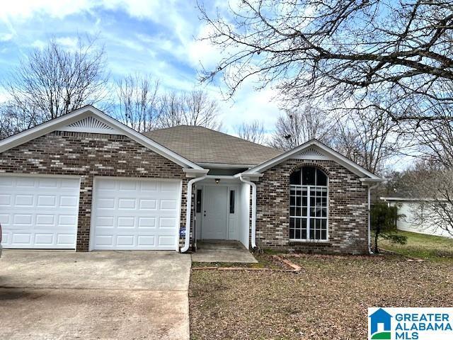 ranch-style house with concrete driveway, brick siding, and an attached garage