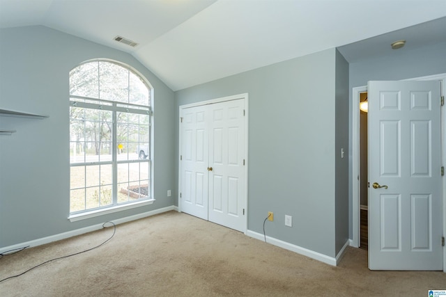 unfurnished bedroom featuring multiple windows, visible vents, and carpet flooring