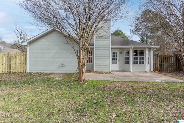 back of house with fence, a lawn, and a patio