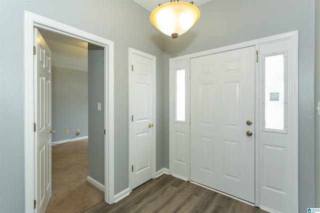 foyer with baseboards and dark wood-style flooring