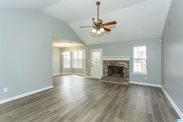 unfurnished living room featuring a brick fireplace, plenty of natural light, a ceiling fan, and wood finished floors