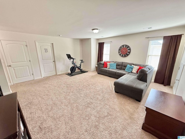 living room with light colored carpet, visible vents, and baseboards