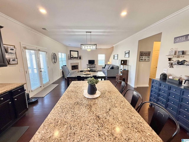 dining area featuring recessed lighting, dark wood-type flooring, a fireplace, baseboards, and ornamental molding