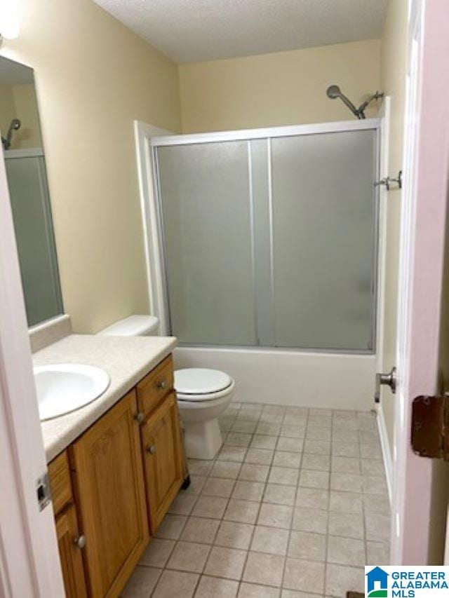 bathroom with toilet, enclosed tub / shower combo, tile patterned flooring, a textured ceiling, and vanity