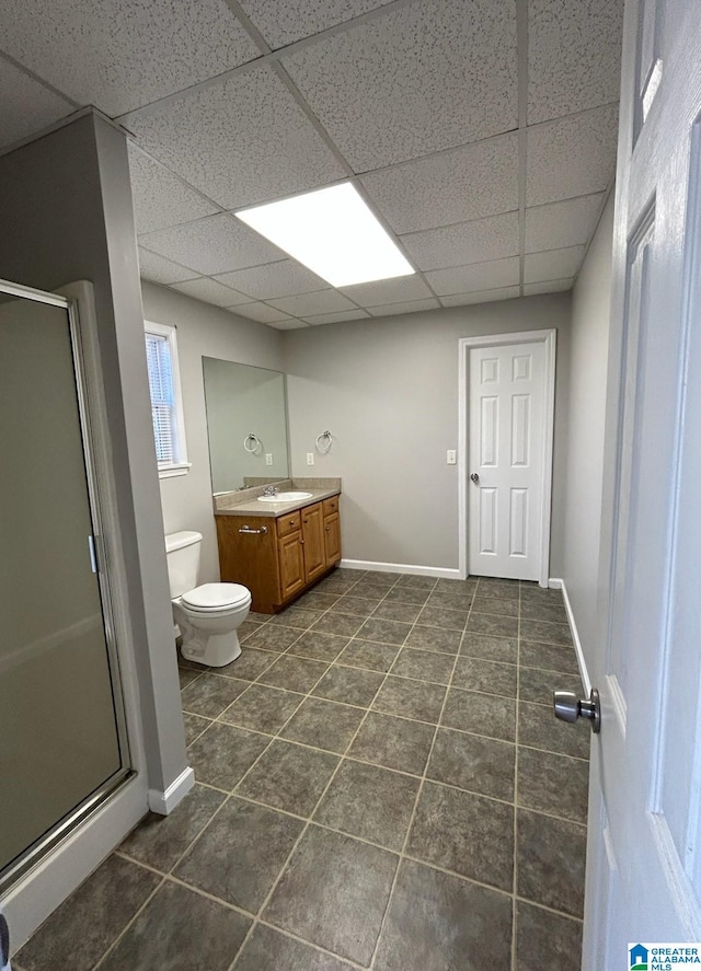 bathroom with a stall shower, toilet, tile patterned floors, vanity, and a paneled ceiling