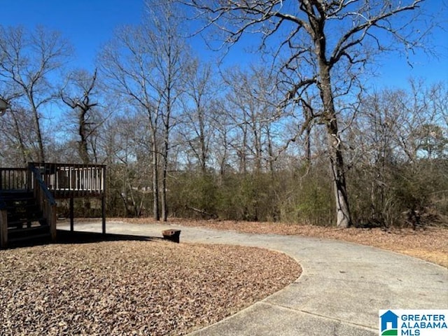 view of yard featuring a deck and concrete driveway